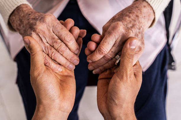 A caregiver holding a patient's hands